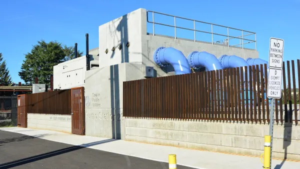 Pump station with blue pipes coming out of concrete wall in Seattle, Washington.