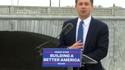 U.S> Department of Transportation Secretary Pete Buttigieg delivers a speech in front of a bridge in Washington, D.C. The podium where he stands has a sign that reads: "Building a Better America."