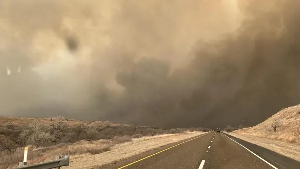 Two-lane asphalt road with smoke filling the sky in Texas Panhandle.