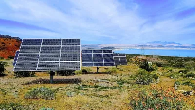 Solar panels installed ona hillside with Lake Mead, Nevada in background.