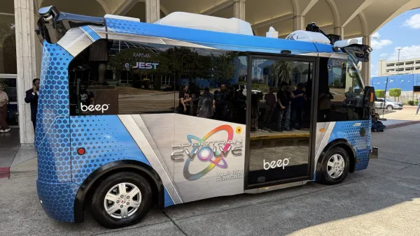 A small blue and white automated bus