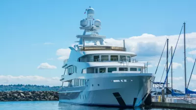 A very large yacht at berth in Washington, with wooded hills in the background.
