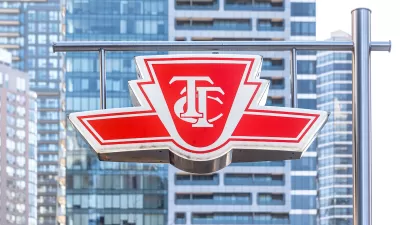 The TTC logo is visible on a sign with the high-rises of Toronto in the background.