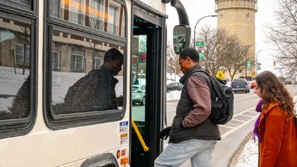 Man and woman boarding bus on winter day in Ann Arbor, Michigan.
