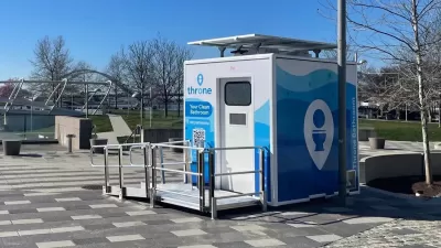 Blue and white Throne portable bathroom in an outdoor location.