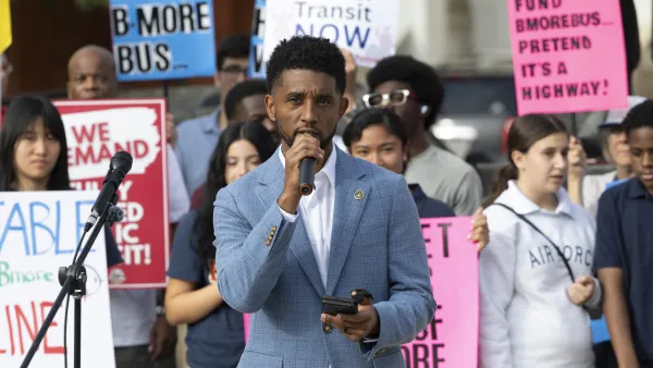 The mayor of Baltimore speaks into a microphone in front of a rally for more state transportation funding from Maryland. 