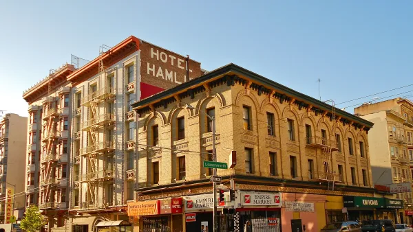 Mid-rise vintage SRO brick hotel building with ground floor retail and "Hotel Hamlin" painted sign on side in Tenderloin district, San Francisco.