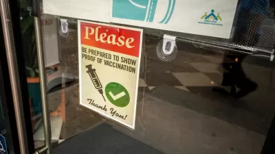 A sign on a door says proof of vaccine is required to enter.