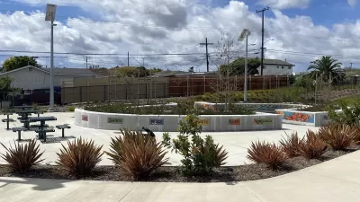 Concrete walkway with landscaping, decorative tiles, and picnic tables in a Los Angeles County park.