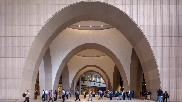 Large arched doorway at entrance to Boston's South Station train station after 2025 renovation with crowd of people walking around at bottom.