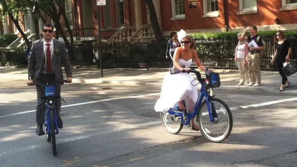 A bride and groom riding on citi bikes in New York