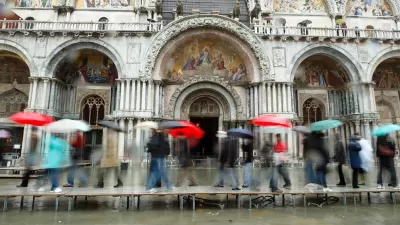 Tourists on walkways over flood waters in Venice