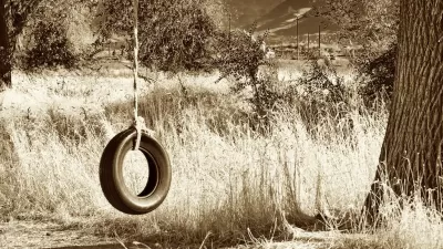 Child's swing made out of a tire and rope hanging from a tree in