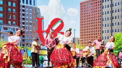 A group of Latino dancers and musicians perform in front of the Love sculpture in Philadelphia.
