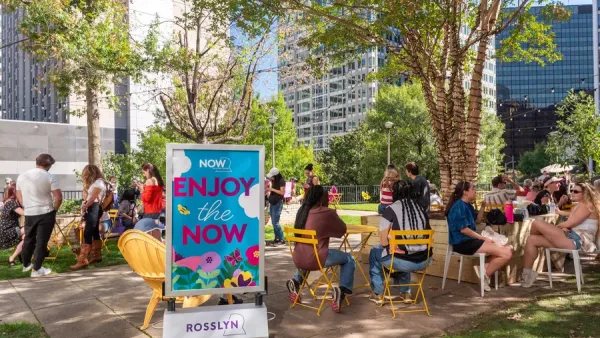 Pop-up park with people sitting at yellow outdoor furniture.