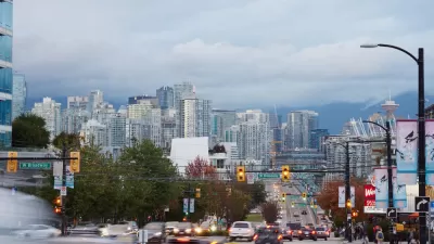 View of downtown Vancouver, British Columbia from middle of road busy with cars and buses