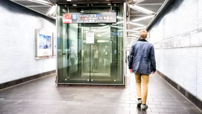 Man walking away past glass elevator in brightly lit New York City subway station corridor