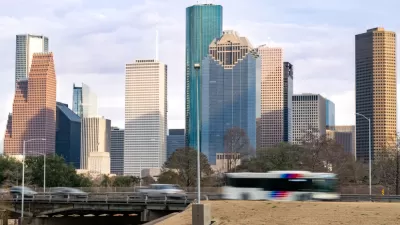 View of Houston freeway with bus, cars, and downtown skyline in background