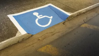 Sidewalk curb cut painted with blue and white disability symbol