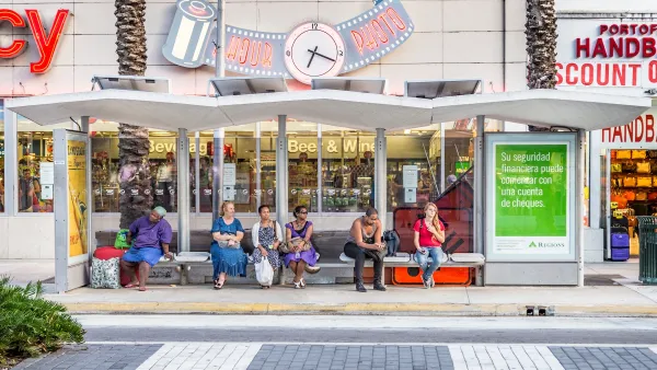 People waiting at a covered bus stop in Miami, Florida.