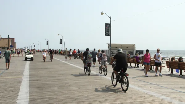 People riding bikes and walking on boardwalk in Long Beach, New York.