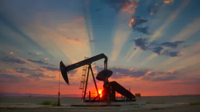 Oil well pump jack sillhouetted against a colorful sunset sky in California's San Joaquin Valley