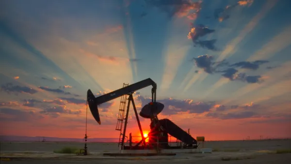 Oil well pump jack sillhouetted against a colorful sunset sky in California's San Joaquin Valley