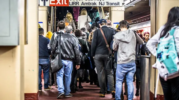 Crowded NYC subway station with signs for Long Island Railroad and NJ Transit.