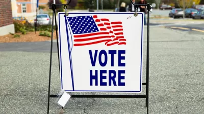 "Vote Here" sidewalk sign with American flag