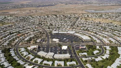 Aerial view of circular street pattern with buildings in Sun City, Arizona with desert mountains in background
