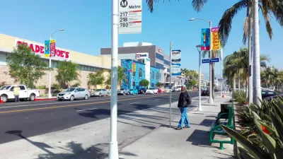 Sidewalk bus stop with bench and no shade in Los Angeles, California