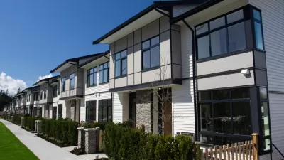 Row of white two-story townhomes with black trim
