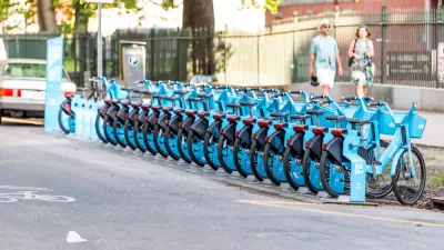 Row of blue New Orleans bike share bikes at a docked station on street