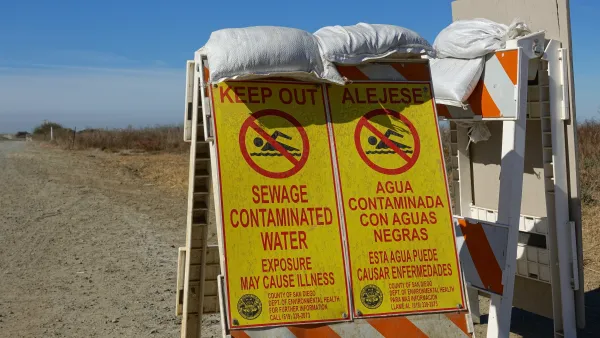Signs in English and Spanish warn of sewage contamination on hiking trail and beach near Tijuana River.