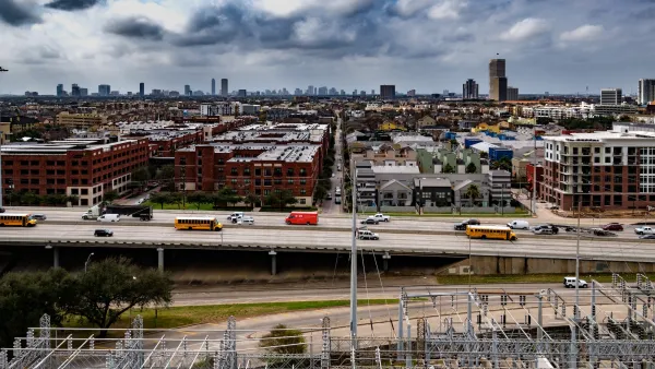 Houston, Texas skyline visible over a freeway with storm clouds in background.