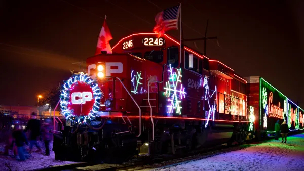 Train locomotive decorated with lights and snowfkale symbols for Christmas at night.