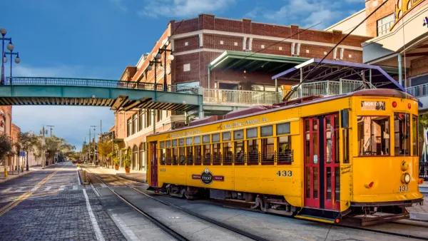 Yellow Tampa streetcar passingon street in Ybor City