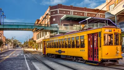 Yellow Tampa streetcar passingon street in Ybor City