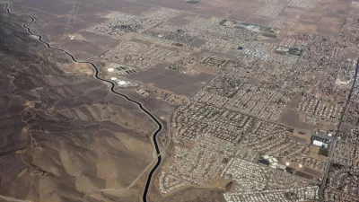 Aerial view of California Squeduct snaking past housing developments in the Mojave Desert