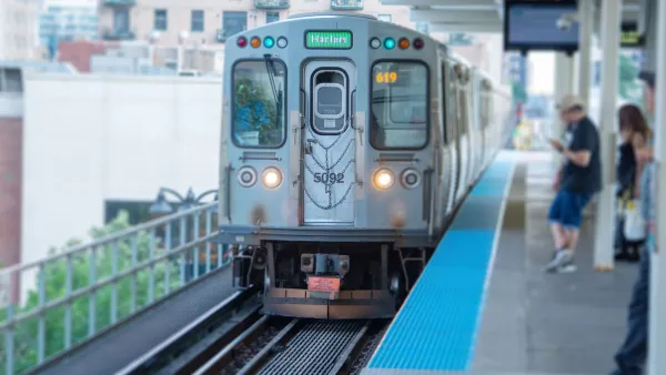 Silver CTA train pulling into elevated platform station in Chicago, Illinois.