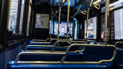 Close-up view of empty bus from behind seat. Seats have blue upholstery