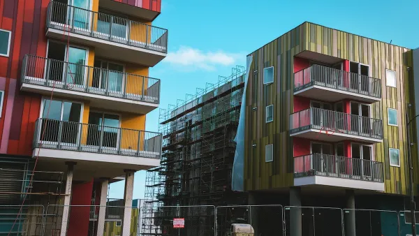 Green and red modern multistory apartment buildings under construction in Los Angeles.