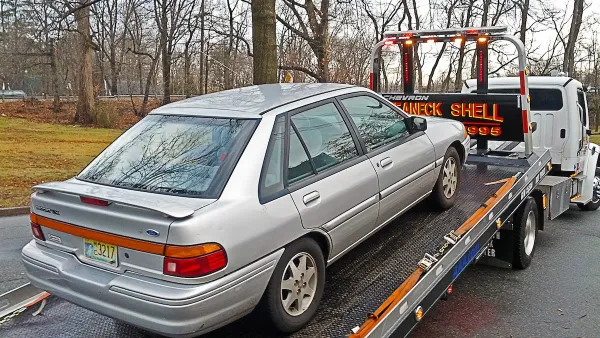 Silver car on back of tow truck.