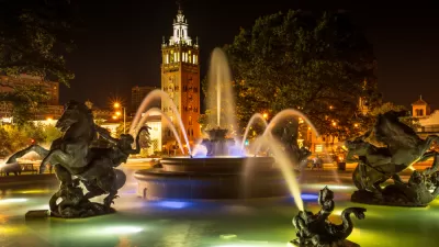 Nighttime shot of decorative fountain with horses and Country Club Plaza tower in background
