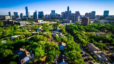Aerial view of green trees over residential neighborhood with Austin, Texas skyline in the background
