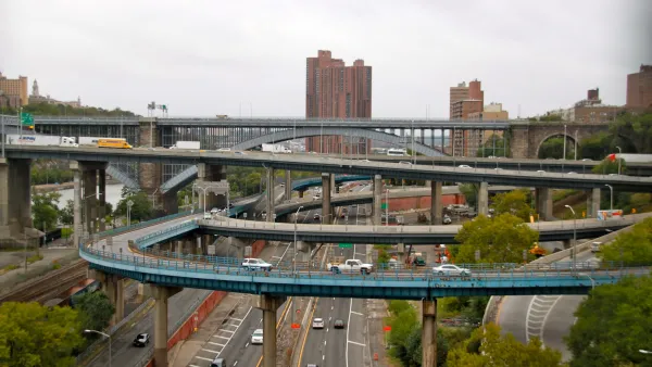 The ramps of the interchange between the Major Deegan Expressway and the Cross Bronx Expressway in New York City with tall brick public housing towers visible in background.