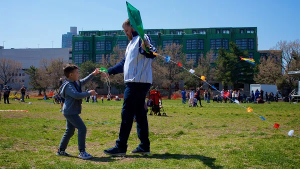 Child and adult man playing with kite in park in Philadelphia, Pennsylvania on a sunny day.