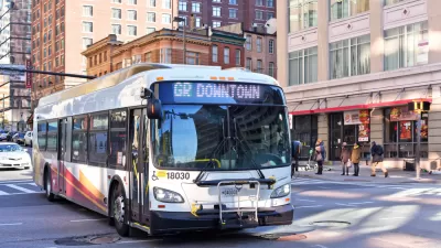 White public bus on street in Baltimore, Maryland with brick buildings in background