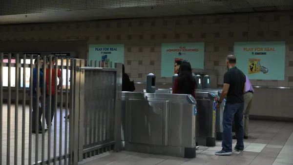 People entering silver fare gates in Los Angeles Metro station.