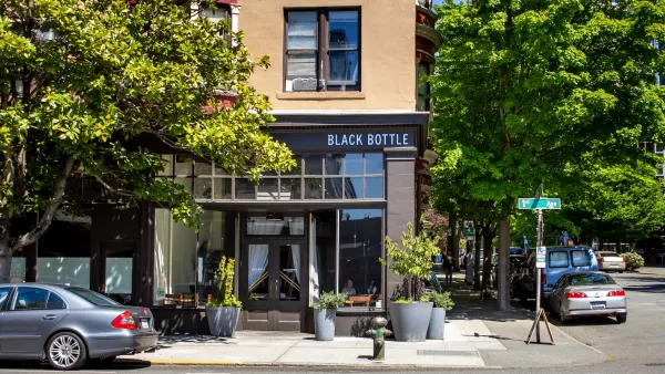 Cafe on corner of small street with leafy trees on sunny day in Seattle, Washington.